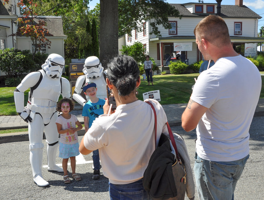 These parents seem to be okay with their kids posing for pics with a couple of Stormtroopers—but aren't they the bad guys in the Star Wars universe? Guess I should ask the Google.